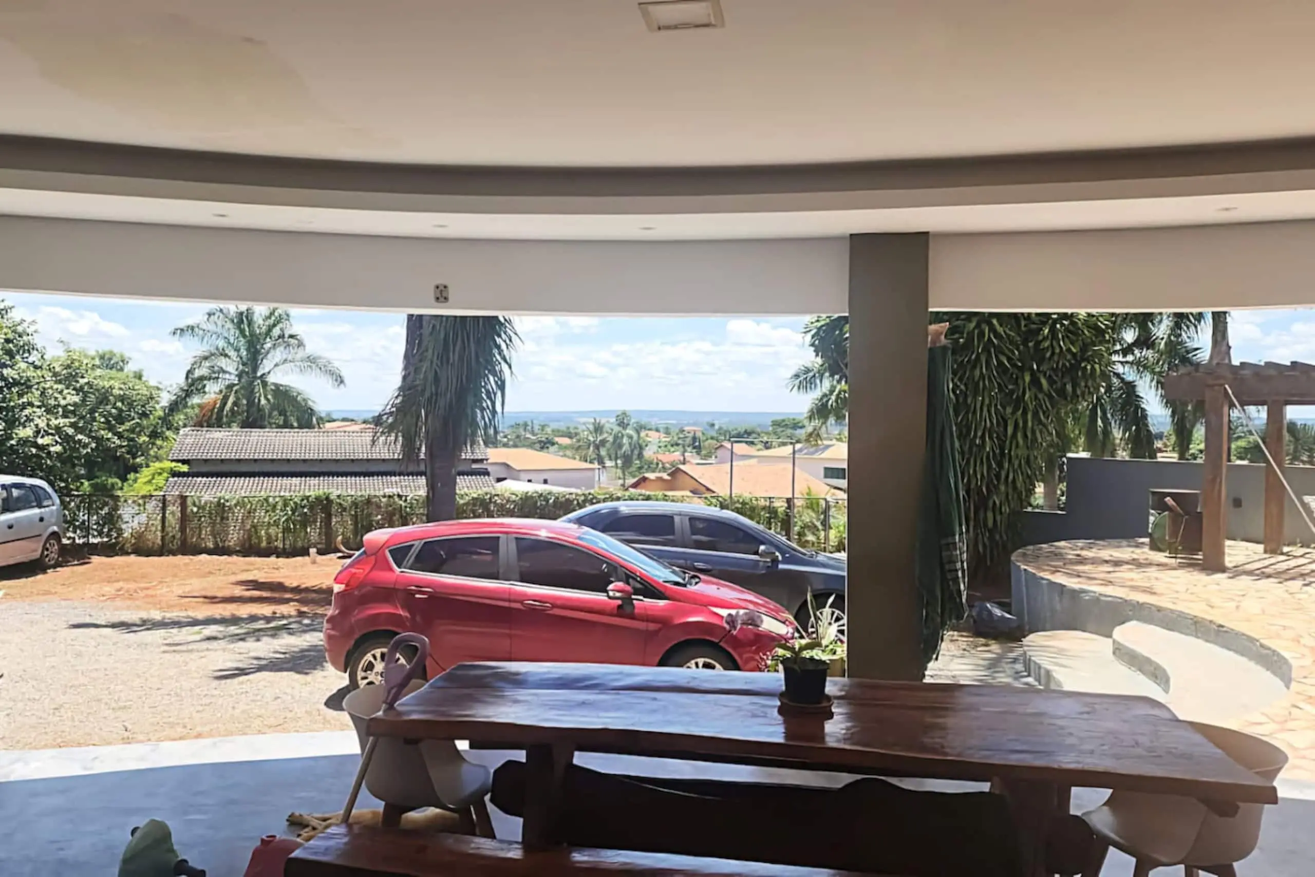 Garagem coberta integrada à varanda, com vagas para diversos veículos.