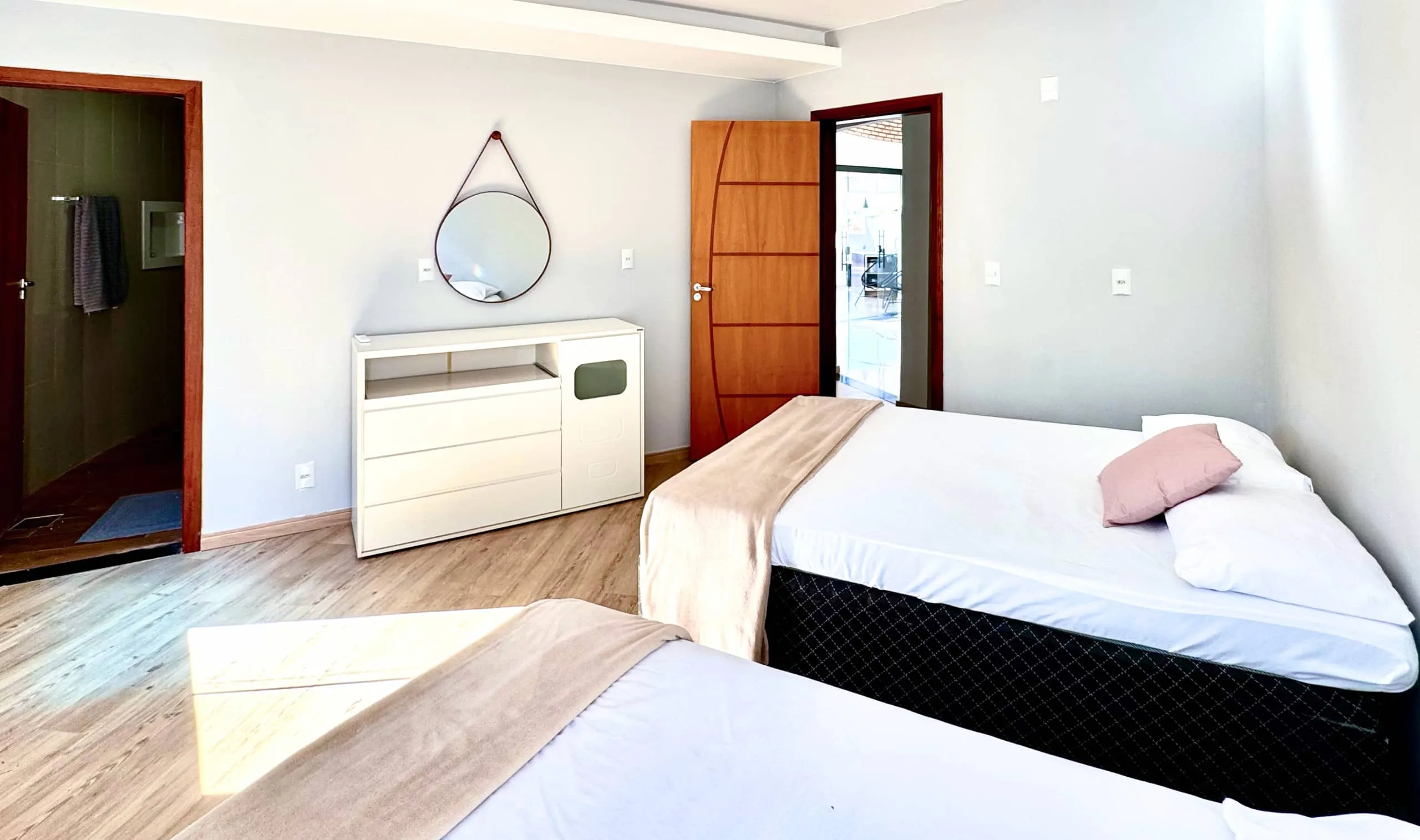 Quarto com duas camas de casal separadas, cortinas blackout e ar-condicionado.