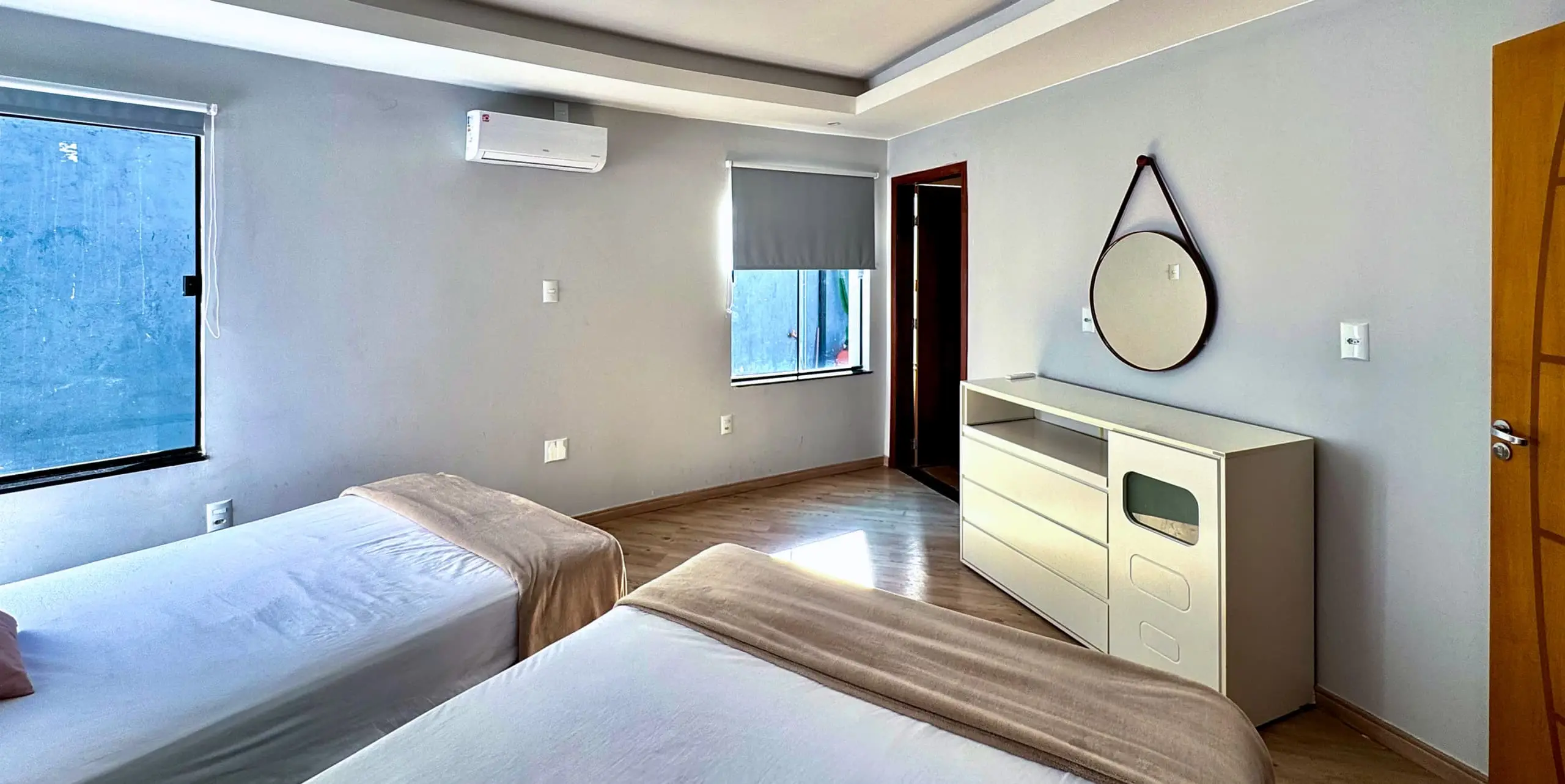 Suíte da Casa Redonda, com ar-condicionado e cortinas blackout.