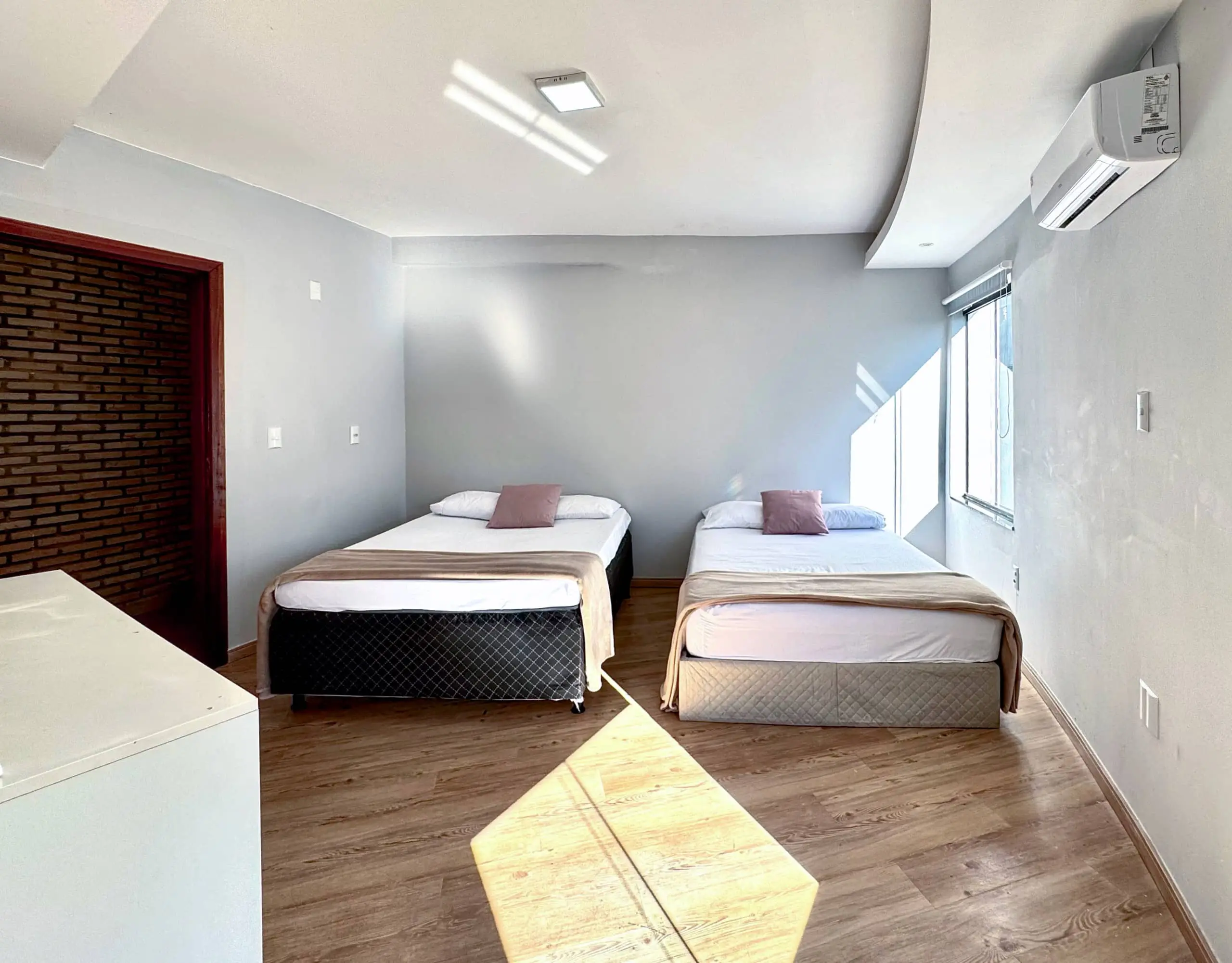 Suíte da Casa Redonda, com ar-condicionado e cortinas blackout.