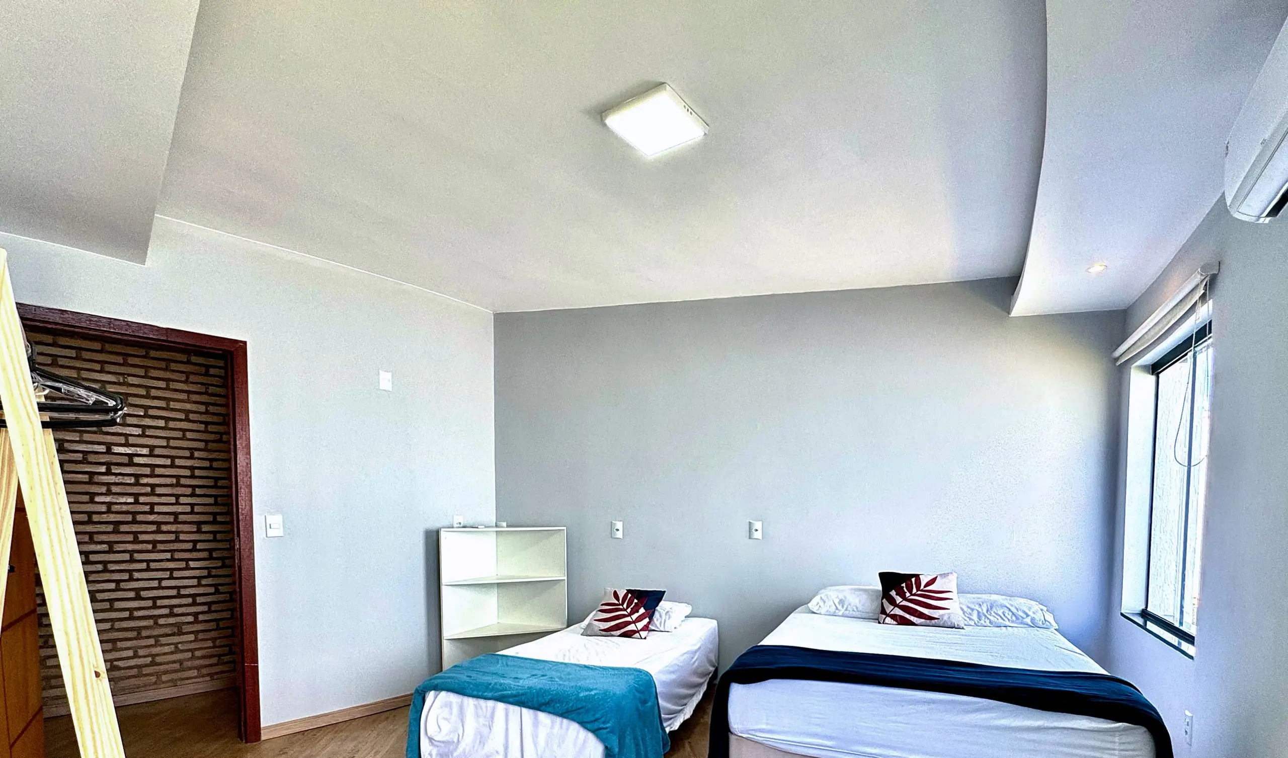 Suíte da Casa Redonda, com ar-condicionado e cortinas blackout.